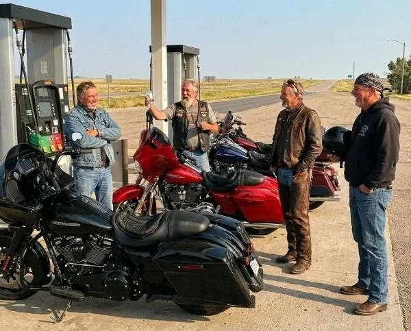 Cuatro moteros charlan en la gasolinera, motos equipadas con SelleZen